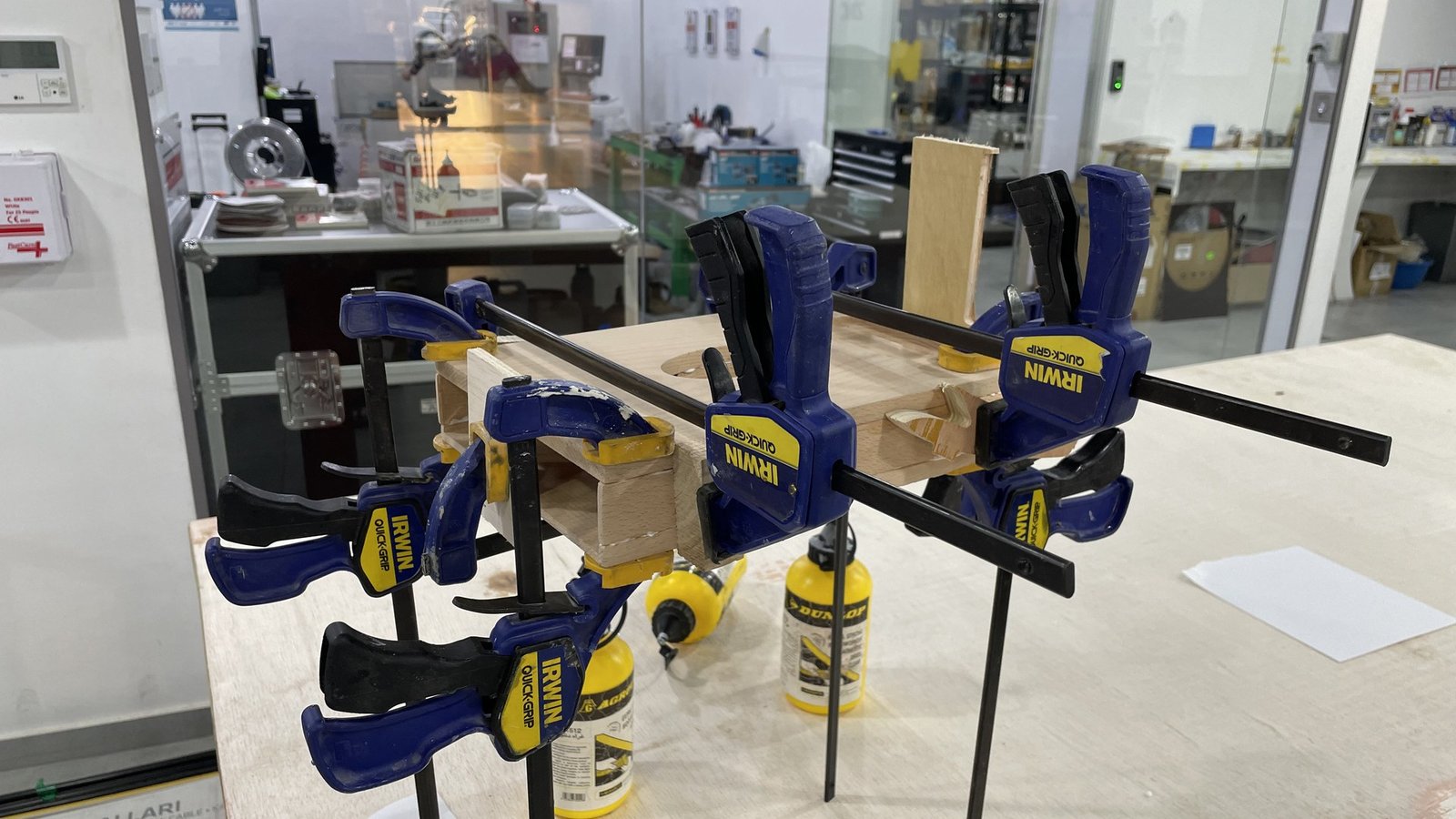 Pieces of the wooden base glued and held in clamps in the workshop.