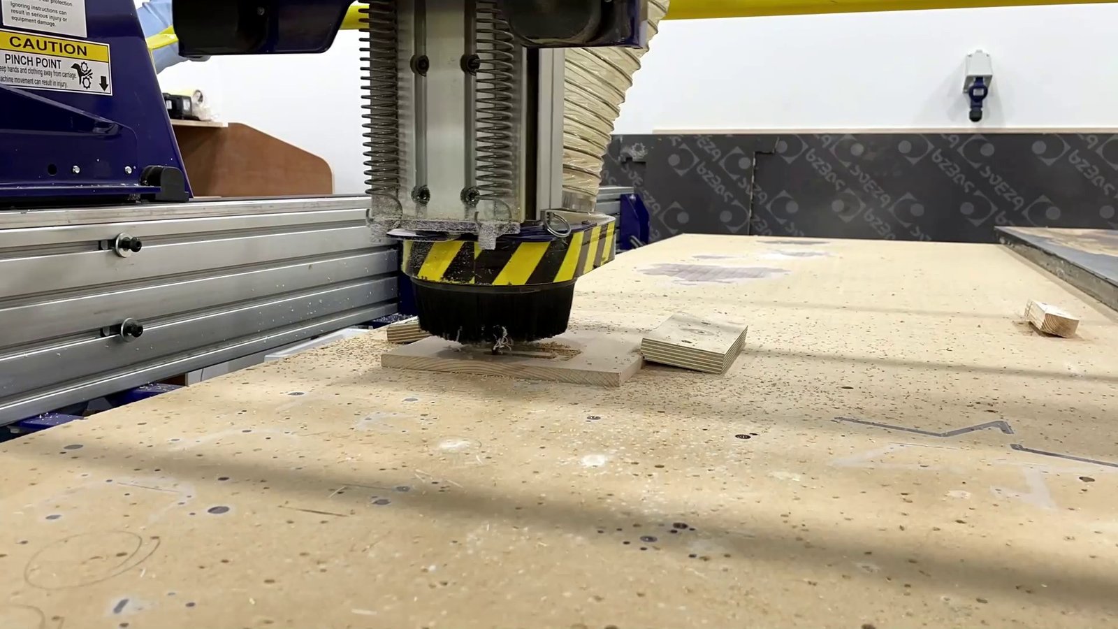 The CNC router cutting a piece of the wooden base.
