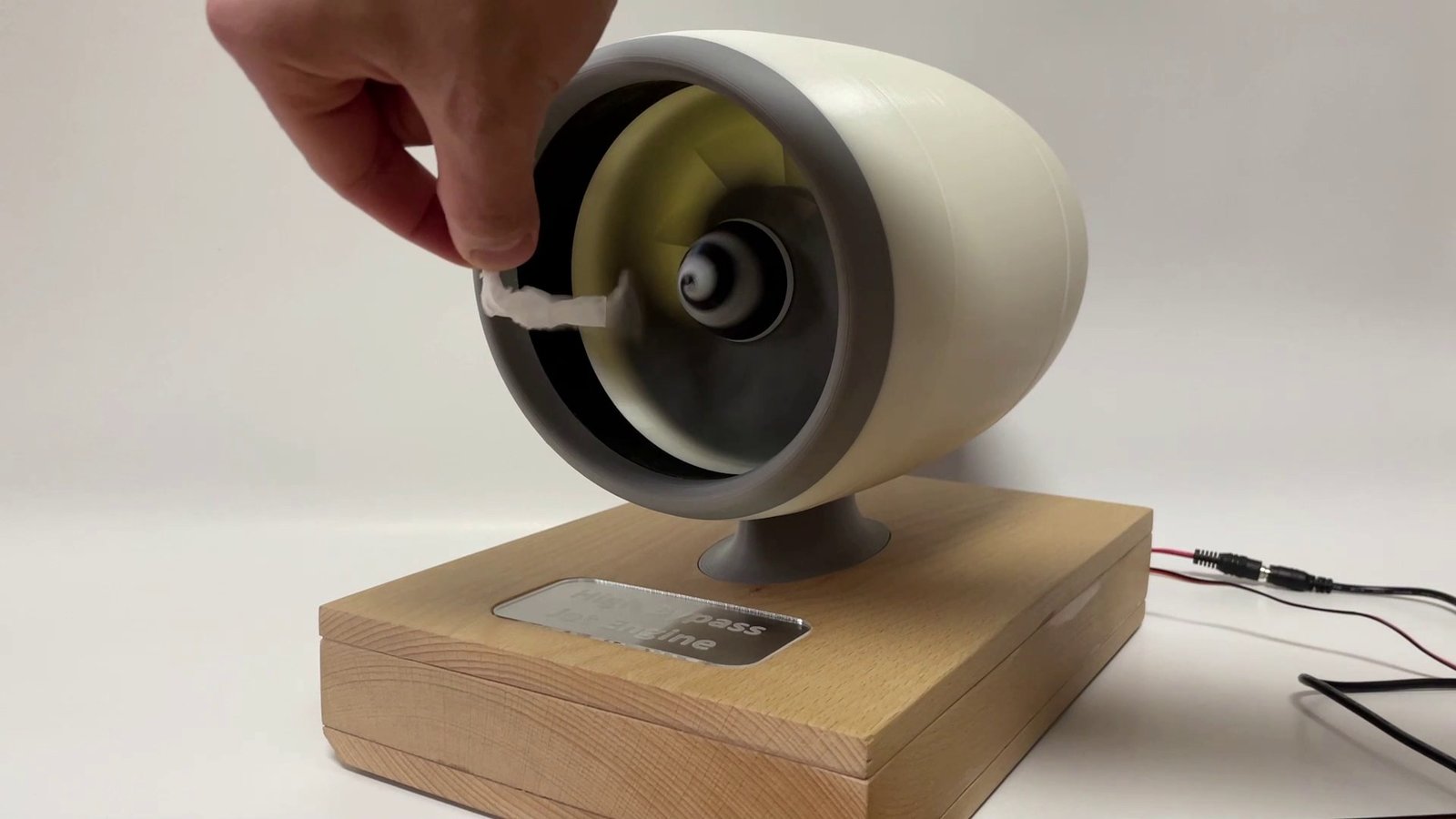 A tissue held at the intake of the running engine, pulled toward the spinning fan.