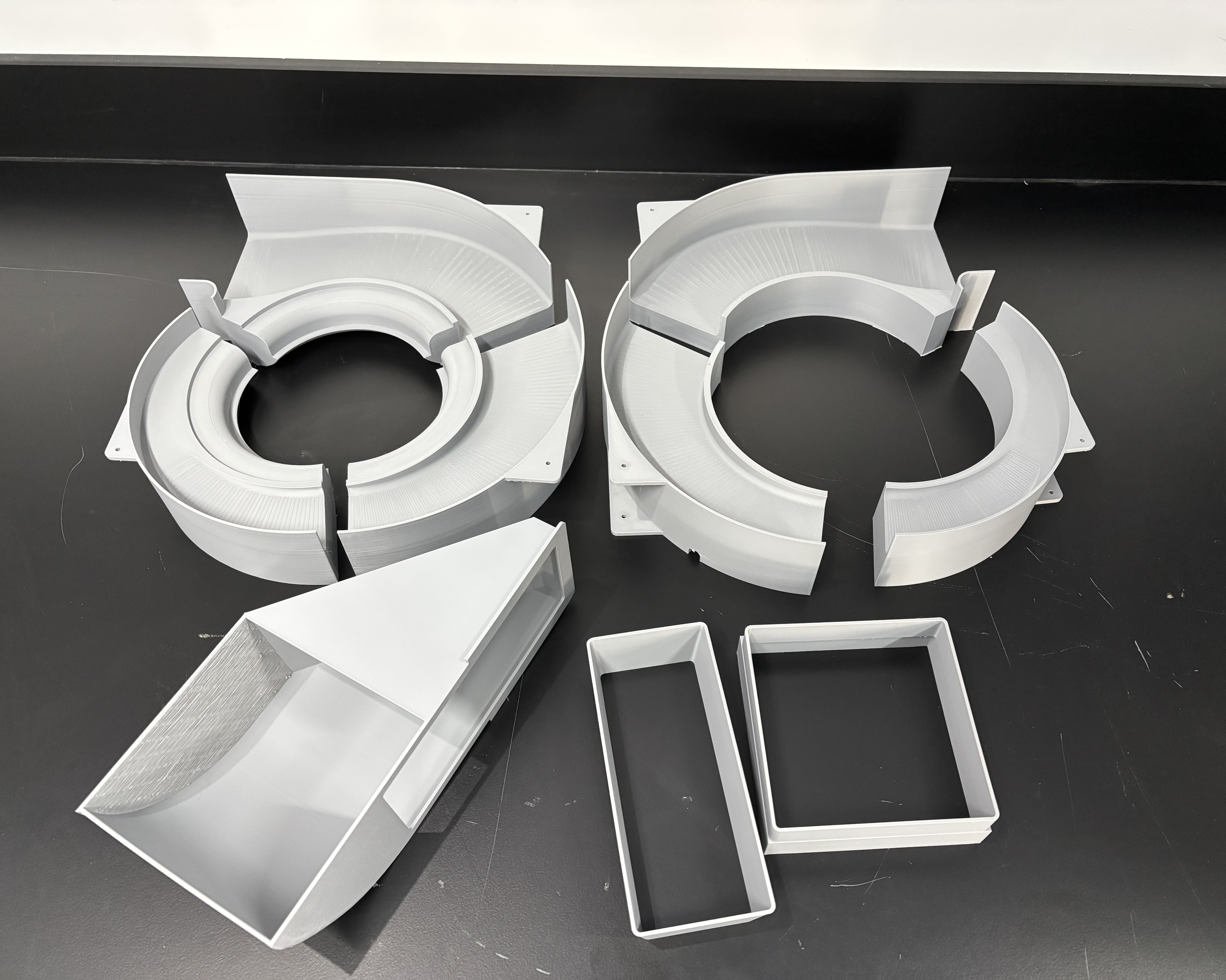 The 3D-printed scroll housing, duct, and trays before assembly.